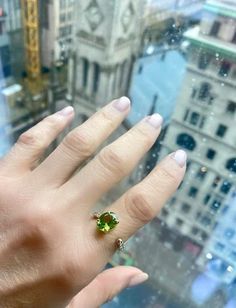 a person's hand with a ring on top of a building in the city