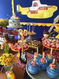 a table filled with cakes and cupcakes on top of plates