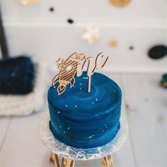 a blue cake sitting on top of a wooden table