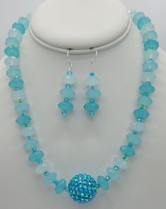 The 19 inch necklace is made with a sparkly round baby blue specialty bead in the center (1  inch circumference).  The rest of the necklace is made with matching round quartz beads and seed beads.  The closure on the necklace is a sterling silver toggle clasp.  Matching earrings are made with round quartz beads and the seed beads.  The earrings hang a total of 2 inches and have a sterling silver earring wire. Blue Round Czech Glass Jewelry, Adjustable Aquamarine Round Jewelry, Adjustable Round Aquamarine Jewelry, Adjustable Aquamarine Bracelet, Adjustable Aquamarine Jewelry, Round Turquoise Aquamarine Necklace, Turquoise Aquamarine Round Necklace, Turquoise Aquamarine Necklace, Blue Sterling Silver Beaded Necklace With Faceted Beads