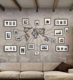 a living room filled with furniture and lots of framed pictures on the wall above it