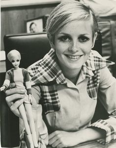 a woman sitting at a desk with a doll and an umbrella in front of her