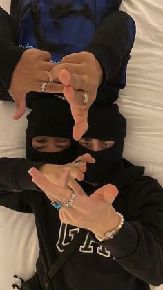 two people in black hoodies pointing fingers at each other