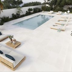 an empty swimming pool surrounded by lounge chairs