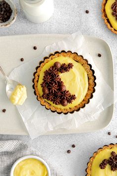 there is a pie with chocolate sprinkles on it and two cups next to it