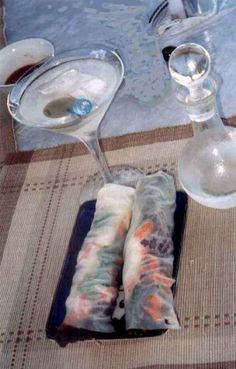 the table is set with wine glasses, silverware and napkins for two people to eat