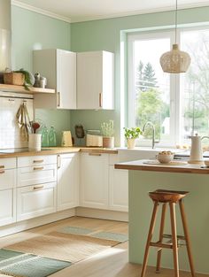 a kitchen with green walls and white cabinets