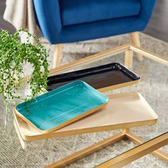 three trays on top of each other with plants in the middle and blue chairs behind them