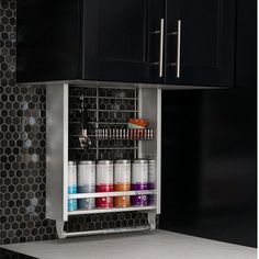 an organized cabinet in the kitchen with paint bottles