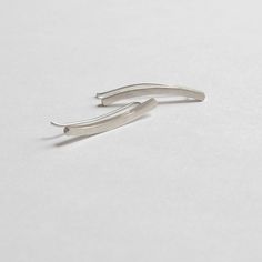 "Long curved square bar gracefully contours of the lower ear making them simple and modern enough to be worn on a daily basis. These 25.4mm ear climbers bars are soldered with solid 20mm sterling silver posts. + Bar Material - Brass, & Sterling Silver + Bar Measurements - 25.4mm (1\") x 2mm x 2mm + Post Gauge - 20ga + Post Length - 20mm + Brass Post Material - Sterling Silver + Sterling Silver Post Material - Sterling Silver + Finish - Matte & Polished + Listing is for a pair + Packaged Bar Measurements, Ear Sweeps, Ear Crawlers, Square Bar, Ear Climber, Minimalist Studs, Ear Climbers, The Ear, It Goes On