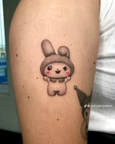 a person with a tattoo on their arm that looks like a cartoon bunny holding a balloon