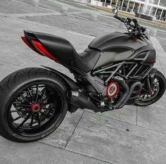 a black motorcycle parked on top of a sidewalk