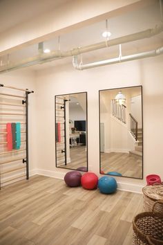 a room with mirrors, exercise balls and yoga mats on the floor in front of it