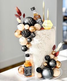 a white cake with black and gold decorations on it's side, sitting on a table