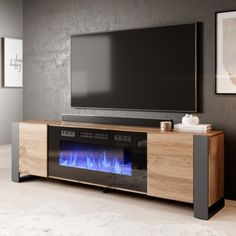 an entertainment center with a television and fire place in the middle, along with a large flat screen tv mounted above it