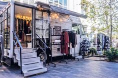 a food truck parked in front of a building with clothes hanging on the outside wall