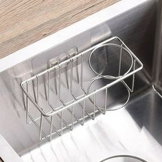 a stainless steel dish rack in the middle of a kitchen sink