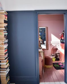 an open door leading to a room with books on the floor and a fireplace in the corner