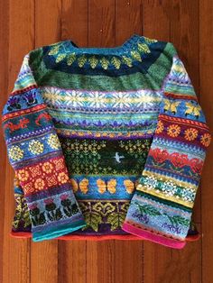 a colorful sweater sitting on top of a wooden floor