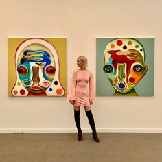 a woman standing in front of two paintings