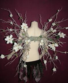 a mannequin with white flowers and leaves on it