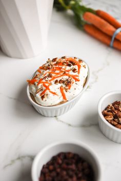 carrots, raisins and whipped cream in small bowls on a white counter