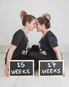 two women sitting next to each other holding signs that say 15 weeks and 1 week