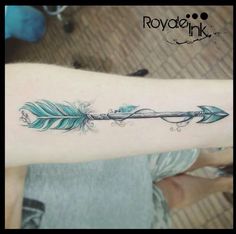 a woman's arm with an arrow and feathers tattoo on the left side of her arm