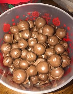 a bowl filled with chocolate covered candy on top of a wooden table