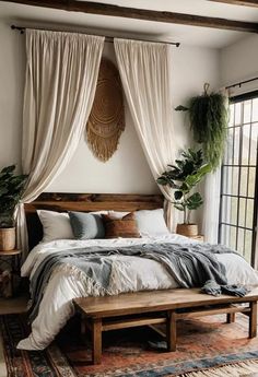 a large bed sitting under a window next to a wooden bench