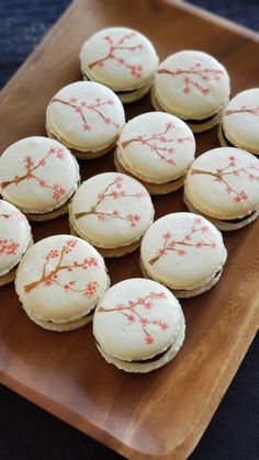 small cookies with white icing and red flowers on a wooden platter, ready to be eaten