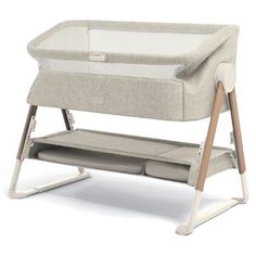 a baby crib that is sitting on top of a white surface with a wooden frame