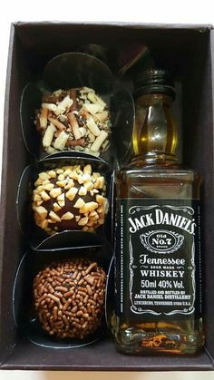 an open box filled with different types of liquor and nuts, including jack daniels whiskey