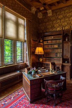 an old fashioned desk in the corner of a room with lots of bookshelves