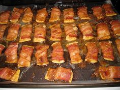 bacon wrapped in small pieces on top of a baking sheet with sauce and seasoning