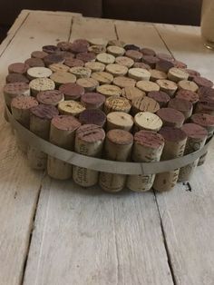 the wine corks are arranged in a circle on top of a wooden table next to a glass