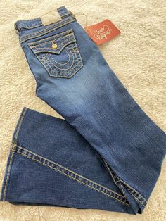 🎁NEW True Religion 'Billy' WOW…🔥THESE ARE RARE ONES…. WIDE LEG … NOS - Jewelled Button Jeans Y2K late 90s, Bootcut/Bell Bottom Size 28. … NEW OLD STOCK …. high quality made item… VINTAGE BUT BRAND NEW NEVER WORN NEVER WASHED….MADE IN USA…. Inseam 35”….Distressed Medium Wash Stretch Blue Denim. Paid close to $250 and then I got pregnant… was always wishing and hoping I could wear but never did… Classic 5 Pocket. Wide bottom. Low Rise. Gold Hardware with Jeweled Crystal Gems. Flap top Back Pockets. Contrast Dark Yellow Topstitching. …Long Leg…..Inner Seam - 34" Rise - 7.5"….99% Cotton 1% Elastane Smoke Free and pet free home… we combine shipping on multiple purchases for some savings…thanks for shopping… blessings Nina Bedazzled Bootcut Jeans, Cute Bell Bottom Jeans, Track Suit Y2k, Trashy Y2k Outfits, Y2k Outfits Shorts, Rise Gold, 2000s Clothing, Button Jeans, Cute Pants