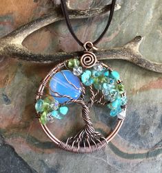 "*Engraving service is not available. This tree of life is made with Blue Opalite Moon using genuine copper wires carefully twisted & wrapped, used the antiquing process to darken/patina, the copper wires and then polished to give that warm & rich look of the finished tree of life. The pendant comes on an antiqued copper finished chain. This family tree made with: April Birthstone August Birthstone December birthstone. All birthstones are mixed and randomly spread on the tree branches. F Moon Tree Of Life, Scarab Necklace, Black Beetle, Family Tree Of Life, Moon Tree, The Family Stone, Wire Wrapped Jewelry Diy, Necklace Moon, Square Necklace