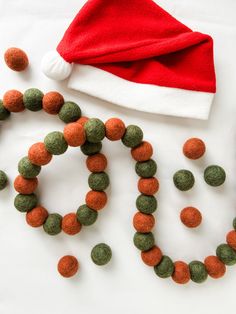 a christmas hat and some balls on a table with the word noel spelled out in it