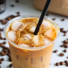 there is a drink with ice and bananas in it on the table next to coffee beans