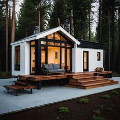 a small white house sitting in the middle of a forest