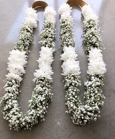 two white flowers are arranged on the floor