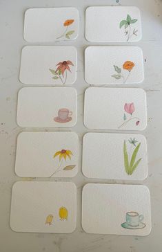 six coasters with different designs on them sitting on a white table next to a cup and saucer