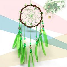 a green dream catcher hanging on a wall next to a colorful striped wallpaper with flowers