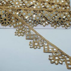 the gold lace has been cut into pieces and is ready to be sewn on