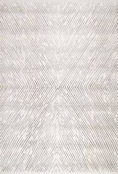 an area rug with white and grey lines on the ground, in front of a gray background