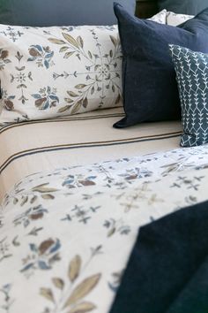 a bed with blue and white pillows on top of it