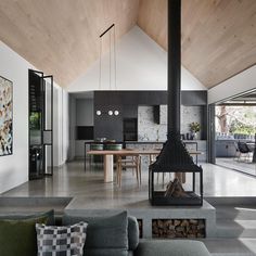 a living room filled with furniture and a fire place in front of a kitchen area