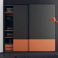 an orange and black wardrobe with two doors on the door is next to a rug