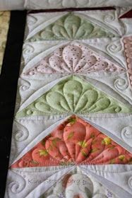 a close up of a quilted table topper with many different designs on it